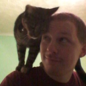 Cleo the cat on my shoulders nuzzling up to my head
